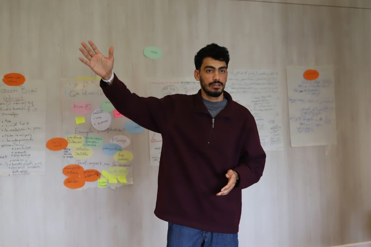 Mohamed Dhia facilitating a training session in front of flip-chart notes